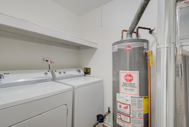 washroom with washing machine and dryer, laundry area, and water heater