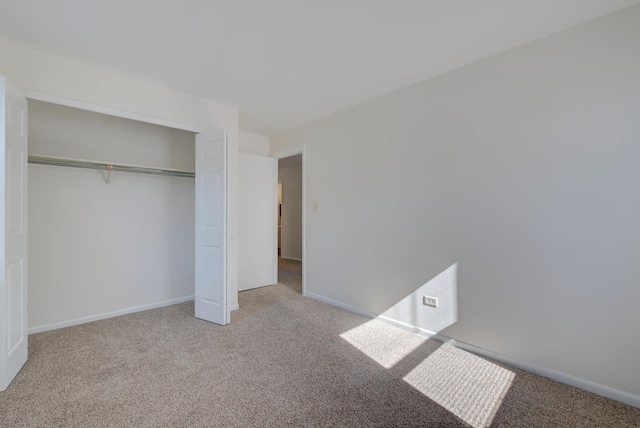 unfurnished bedroom with a closet, baseboards, and carpet flooring