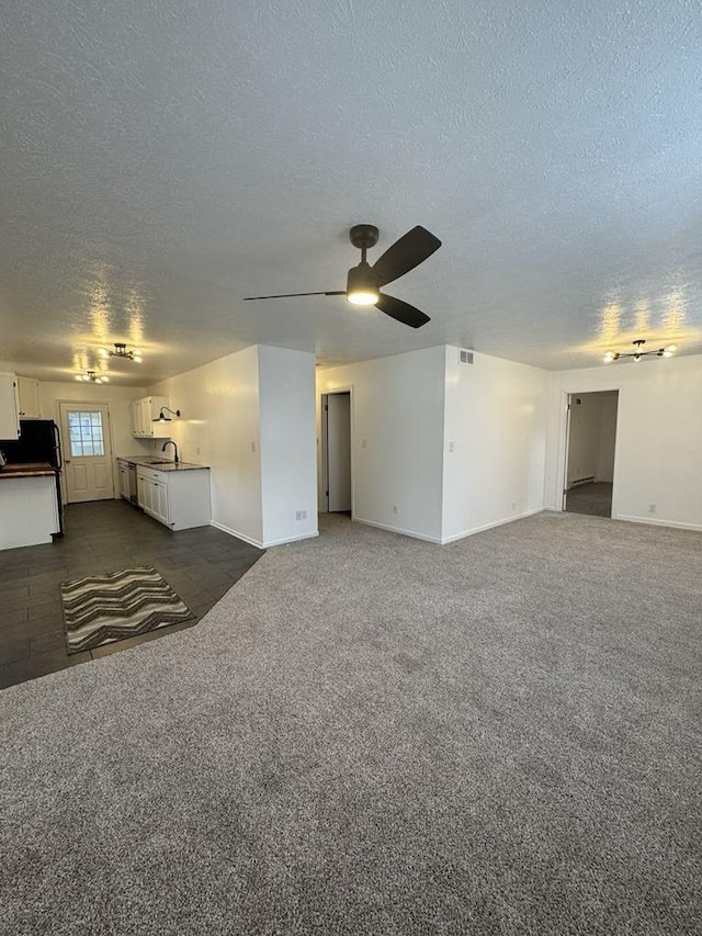 spare room featuring ceiling fan, dark colored carpet, a textured ceiling, and sink