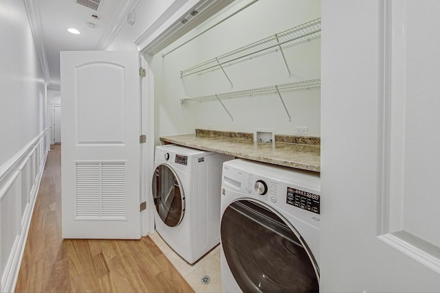 laundry area featuring washer and dryer, laundry area, visible vents, and light wood-style flooring