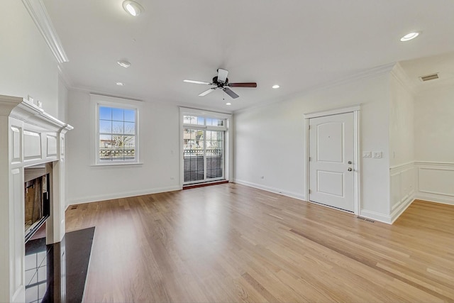 unfurnished living room with a fireplace with flush hearth, recessed lighting, crown molding, and light wood finished floors