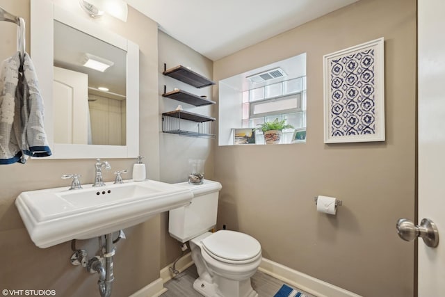 bathroom with visible vents, toilet, and baseboards