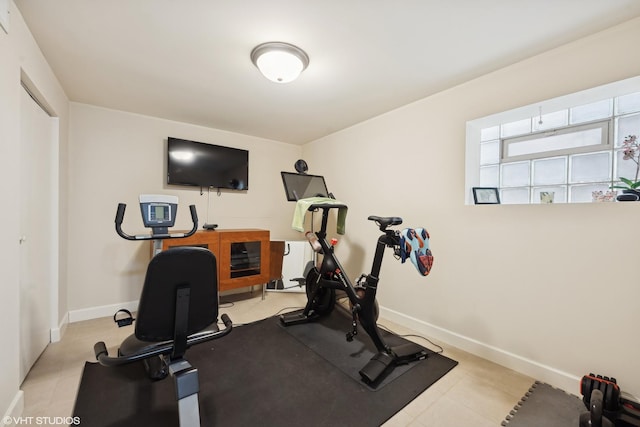 workout area with light tile patterned floors and baseboards