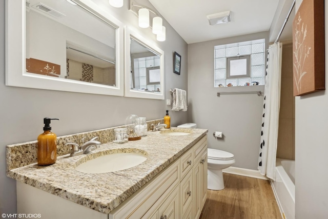 full bath with visible vents, a sink, toilet, and wood finished floors