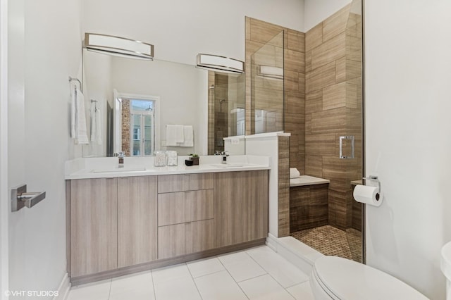 bathroom with vanity, a shower with door, toilet, and tile patterned floors