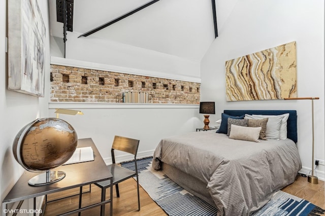 bedroom with vaulted ceiling and wood-type flooring