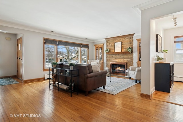 living room with light wood-style floors, crown molding, and a wealth of natural light