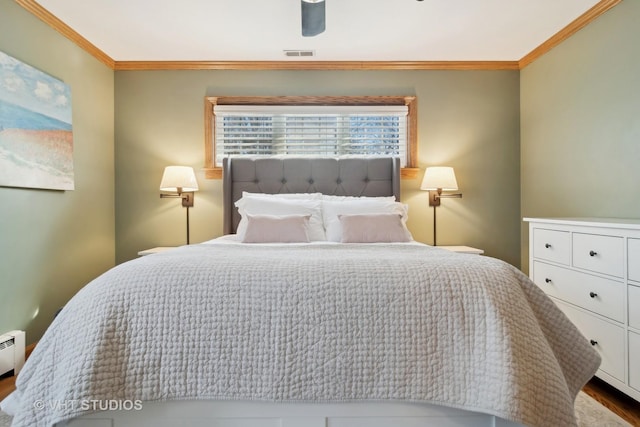 bedroom featuring a ceiling fan, wood finished floors, visible vents, and crown molding