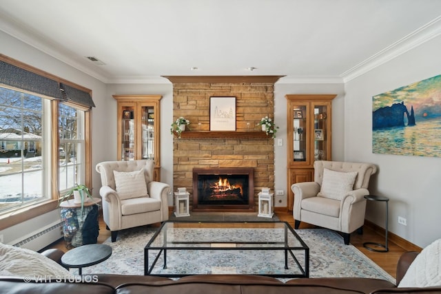 living room with a fireplace, wood finished floors, visible vents, baseboards, and ornamental molding