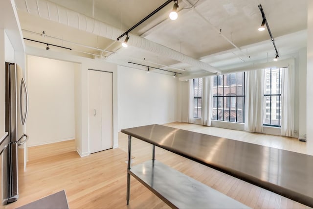 interior space featuring light wood-style floors, freestanding refrigerator, and track lighting