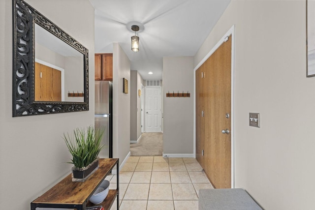 hallway featuring light tile patterned floors and baseboards