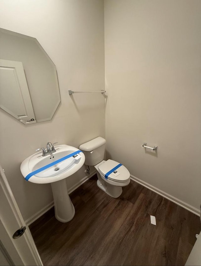 bathroom with toilet and hardwood / wood-style floors