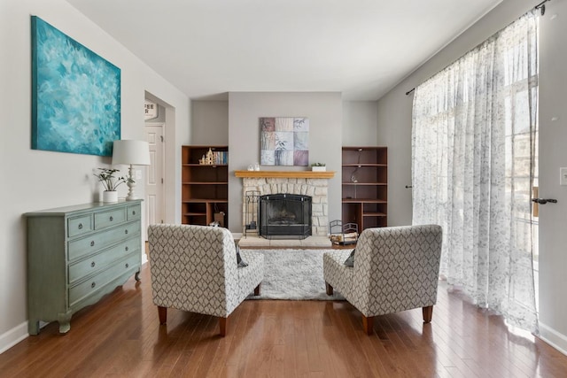 sitting room featuring baseboards, wood finished floors, and a fireplace