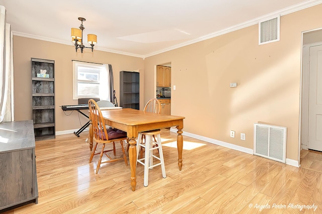 dining area featuring ornamental molding, visible vents, and light wood-style floors