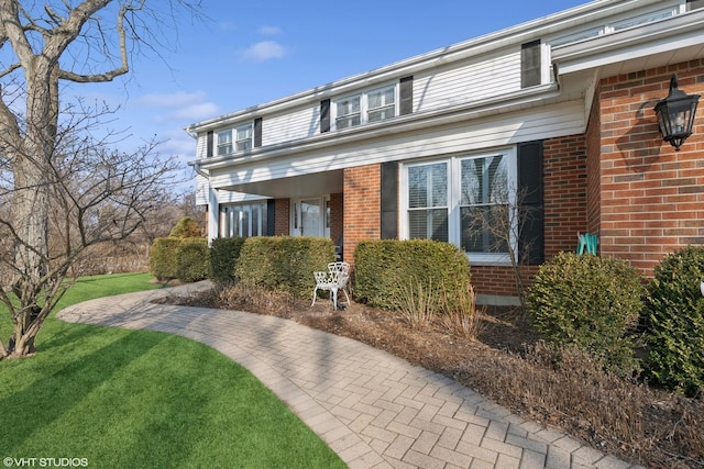 view of front of house with brick siding and a front yard