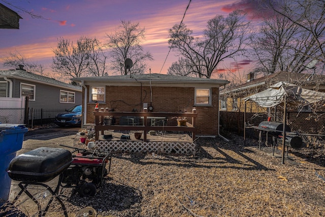 14817 Lexington Ave, Harvey, IL 60426 - back of house at dusk with brick siding, a deck, and fence