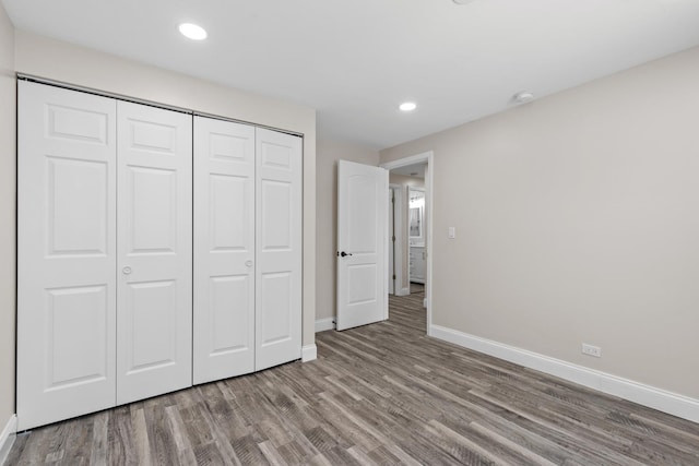 unfurnished bedroom featuring hardwood / wood-style flooring and a closet