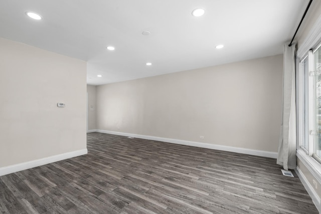 empty room with dark hardwood / wood-style flooring