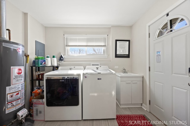 laundry room with gas water heater, light wood-style flooring, a sink, washer and dryer, and laundry area