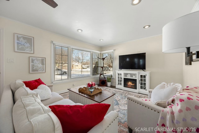 living area with recessed lighting, a warm lit fireplace, and baseboards