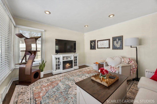 living room featuring dark wood-style floors, recessed lighting, a warm lit fireplace, and baseboards