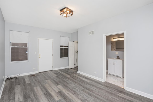 unfurnished living room featuring light hardwood / wood-style floors and sink