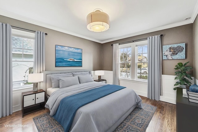 bedroom with ornamental molding, dark wood finished floors, and wainscoting