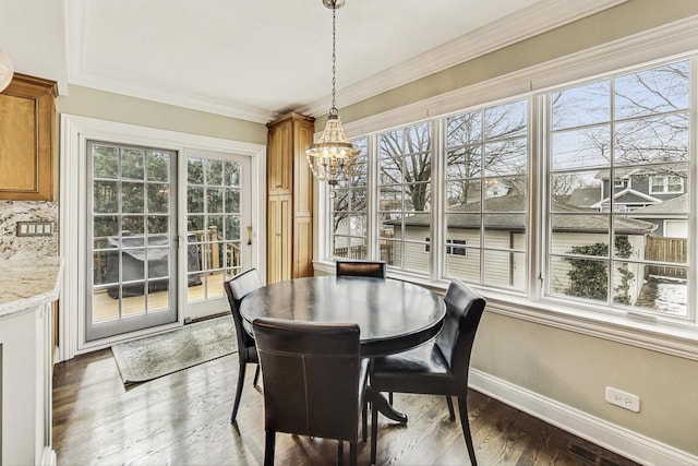 dining area featuring crown molding, wood finished floors, visible vents, baseboards, and an inviting chandelier