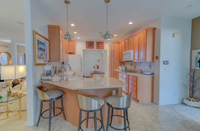 kitchen featuring white appliances, a sink, light countertops, tasteful backsplash, and decorative light fixtures