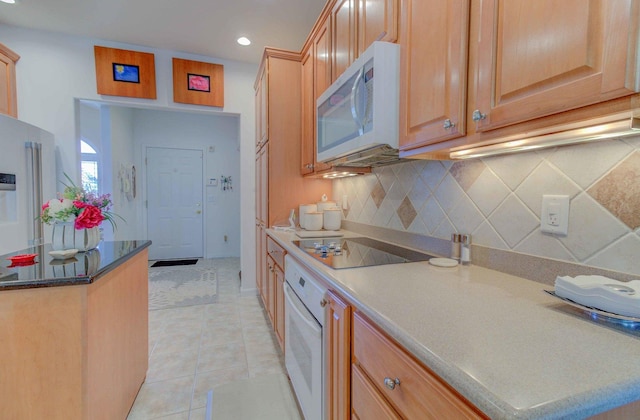 kitchen featuring white appliances, light tile patterned floors, decorative backsplash, and light brown cabinetry