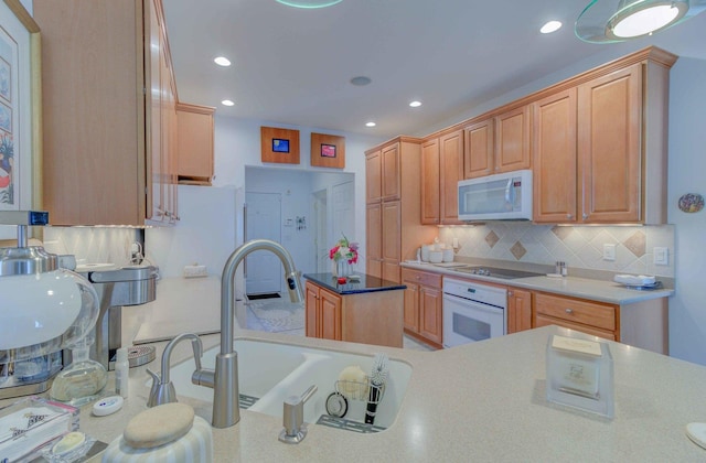 kitchen featuring recessed lighting, white appliances, a sink, light countertops, and tasteful backsplash