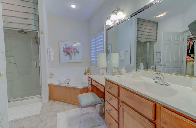 full bath featuring tile patterned floors, a garden tub, a walk in closet, vanity, and a shower stall