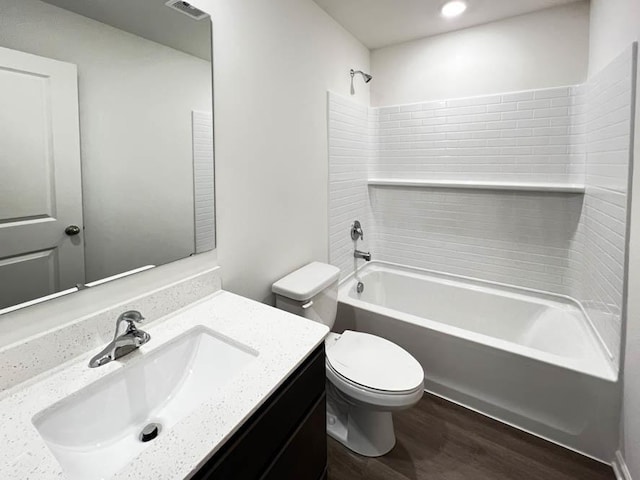 full bathroom featuring hardwood / wood-style floors, toilet, vanity, and shower / washtub combination