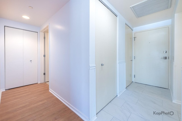 hallway featuring baseboards, visible vents, and recessed lighting