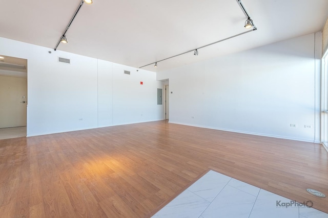 spare room featuring visible vents, light wood finished floors, and rail lighting