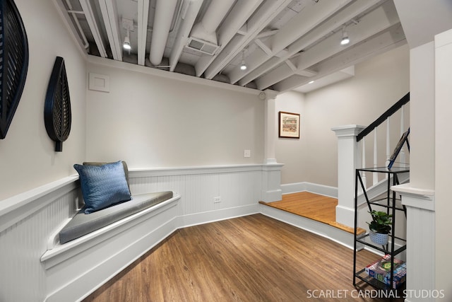 unfurnished room featuring baseboards, visible vents, wainscoting, stairway, and wood finished floors