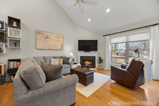 living room featuring a fireplace with flush hearth, high vaulted ceiling, wood finished floors, and recessed lighting