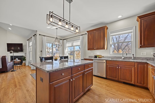 kitchen featuring a center island, pendant lighting, a notable chandelier, light stone countertops, and dishwasher