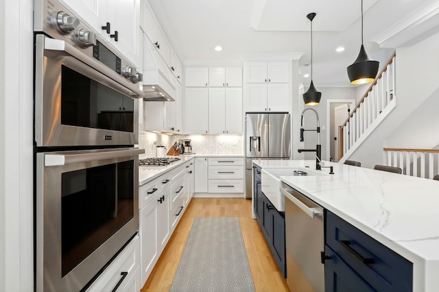 kitchen featuring decorative backsplash, light stone counters, appliances with stainless steel finishes, white cabinetry, and pendant lighting