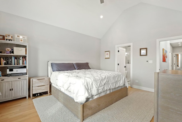 bedroom featuring high vaulted ceiling, baseboards, ensuite bath, and light wood finished floors