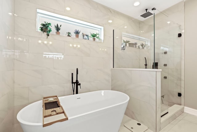 bathroom featuring a soaking tub, a shower stall, and tile walls