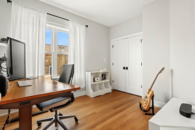 home office with baseboards and light wood-style floors