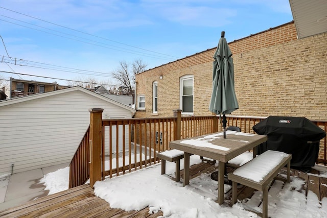 snow covered deck featuring a grill and outdoor dining space