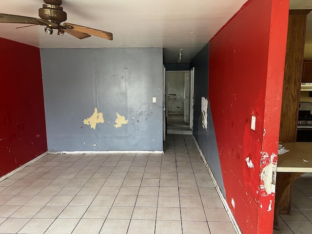 spare room featuring ceiling fan, light tile patterned flooring, and baseboards