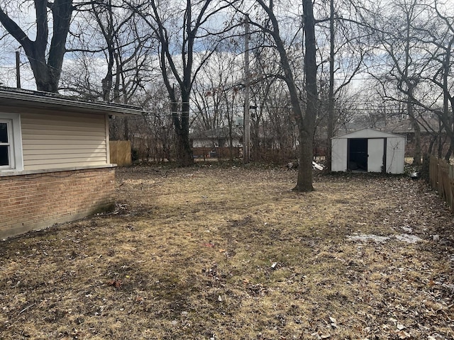 view of yard featuring a storage shed, an outdoor structure, and fence