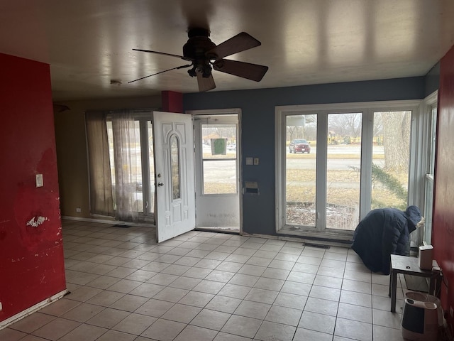 entryway with light tile patterned floors, baseboards, visible vents, and a wealth of natural light