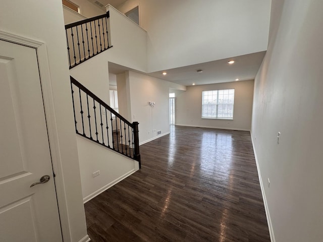 foyer entrance with a high ceiling and dark hardwood / wood-style floors