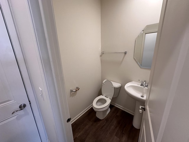 bathroom with sink, toilet, and hardwood / wood-style floors