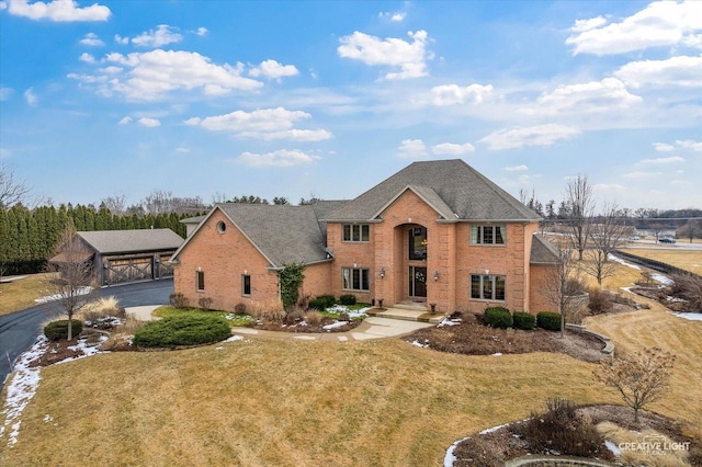 view of front of house with brick siding, a shingled roof, a carport, and a front yard