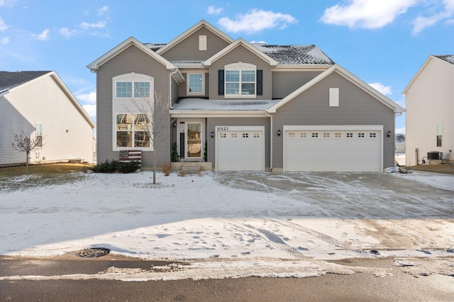 view of front of home with central air condition unit and a garage